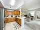Open kitchen concept with wood cabinets, and tiled floors with a view into the living room at 602 Camino Real Blvd # 602, Howey In The Hills, FL 34737