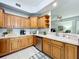 Modern kitchen showcasing stainless steel appliances and ample wood cabinets with open shelving at 602 Camino Real Blvd # 602, Howey In The Hills, FL 34737