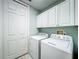 Bright laundry room with a washer, dryer, and plenty of cabinet space for storage needs at 602 Camino Real Blvd # 602, Howey In The Hills, FL 34737