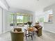 Bright living room featuring chairs, a table, and a screened patio with golf course view at 602 Camino Real Blvd # 602, Howey In The Hills, FL 34737