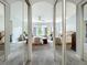 View of the spacious main bedroom through mirrored closet doors, showcasing seating areas and a ceiling fan at 602 Camino Real Blvd # 602, Howey In The Hills, FL 34737