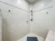 Neutral-toned shower with chrome hardware, decorative tile accents, and a stone corner seat at 602 Camino Real Blvd # 602, Howey In The Hills, FL 34737