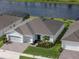 Aerial view of house boasting brick driveway, gray roof, & manicured lawn at 6308 Mossy Oak Rd, St Cloud, FL 34771