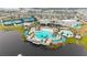 Aerial view of a luxurious resort-style pool with palm trees, lounge chairs, and a lake with a fountain at 6308 Mossy Oak Rd, St Cloud, FL 34771