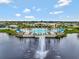 Aerial view of a gorgeous resort-style pool, palm trees, lounge chairs, and a lake with a fountain at 6308 Mossy Oak Rd, St Cloud, FL 34771