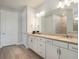 Bright bathroom featuring dual sinks, a large mirror, granite counters and a tiled walk-in shower at 6308 Mossy Oak Rd, St Cloud, FL 34771
