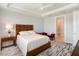 Bright bedroom featuring tray ceilings, a ceiling fan, and a seating area near the ensuite bathroom at 6308 Mossy Oak Rd, St Cloud, FL 34771