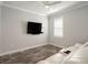 Bright bonus room with ceiling fan, window with shutters, wall mounted TV, and a white leather couch at 6308 Mossy Oak Rd, St Cloud, FL 34771