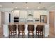 Modern kitchen with white cabinets, a large island with seating, and stainless appliances at 6308 Mossy Oak Rd, St Cloud, FL 34771
