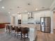 Spacious kitchen island with quartz countertops, seating, and modern pendant lighting at 6308 Mossy Oak Rd, St Cloud, FL 34771