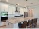 Elegant kitchen showcasing white cabinetry, a large island with barstool seating and modern finishes at 6308 Mossy Oak Rd, St Cloud, FL 34771