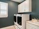 The well-lit laundry room offers a full-size washer and dryer, a sink, and storage cabinets at 6308 Mossy Oak Rd, St Cloud, FL 34771
