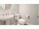 A minimalist powder room offers a pedestal sink, a modern faucet, and a toilet at 6308 Mossy Oak Rd, St Cloud, FL 34771
