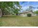 The home's backyard boasts a large lawn, a screen enclosed porch, and mature landscaping for a peaceful outdoor setting at 74 Stone Haven Ct, Leesburg, FL 34788