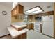 Functional kitchen featuring wooden cabinets, white appliances, and ample counter space at 74 Stone Haven Ct, Leesburg, FL 34788