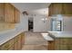 Open kitchen view highlighting wood cabinets and adjoining living space with neutral tones at 74 Stone Haven Ct, Leesburg, FL 34788
