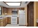 Efficient kitchen with white appliances and wood-finish cabinets at 74 Stone Haven Ct, Leesburg, FL 34788