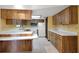 Efficient kitchen featuring natural wood cabinets, a white refrigerator, and a bright overhead light at 74 Stone Haven Ct, Leesburg, FL 34788