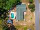 Birds-eye view showcases a house with a green roof, private pool, and neatly kept yard at 8198 Se 164Th Pl, Summerfield, FL 34491
