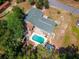 Stunning aerial view of the property featuring a pool, patio, and lush green surroundings at 8198 Se 164Th Pl, Summerfield, FL 34491