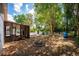 The backyard features a covered patio, fire pit, mature trees, and a blue water tank at 8198 Se 164Th Pl, Summerfield, FL 34491