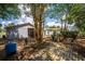 Spacious backyard featuring brick-paved patio, mature trees, and versatile detached garage/workshop, ideal for outdoor living at 8198 Se 164Th Pl, Summerfield, FL 34491
