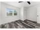 This bedroom offers a ceiling fan, wood-look floors and a window for natural light at 8198 Se 164Th Pl, Summerfield, FL 34491