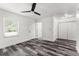 Spacious bedroom showcases wood grain flooring, a modern ceiling fan and double door closet at 8198 Se 164Th Pl, Summerfield, FL 34491