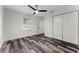 Cozy bedroom features wood grain flooring, a ceiling fan, a window and a double door closet at 8198 Se 164Th Pl, Summerfield, FL 34491