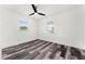 Sunlit bedroom with modern flooring and ceiling fan, featuring two windows at 8198 Se 164Th Pl, Summerfield, FL 34491