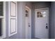 Close-up of the front doors showing detail and design, framed by white trim and the light-blue exterior at 8198 Se 164Th Pl, Summerfield, FL 34491