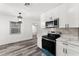 Updated kitchen features white cabinets, stone countertops, stainless steel appliances and wood-look floors at 8198 Se 164Th Pl, Summerfield, FL 34491