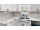 Updated kitchen features white cabinets, stone countertops and modern hardware at 8198 Se 164Th Pl, Summerfield, FL 34491