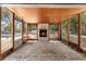 Enclosed patio featuring a brick fireplace, brick flooring, wood-paneled ceiling, and views of the pool at 8198 Se 164Th Pl, Summerfield, FL 34491
