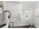 Water heater area features wire shelving, water heater and modern wood grain flooring at 8198 Se 164Th Pl, Summerfield, FL 34491