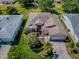 Aerial view of a well-maintained home with a lush green lawn, a paved driveway, and palm trees for a tropical feel at 910 Eagles Lndg, Leesburg, FL 34748