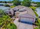 Aerial view showcasing a well-maintained single-story home with manicured landscaping and a brick driveway at 910 Eagles Lndg, Leesburg, FL 34748