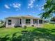A lush green lawn surrounds the home, which features an enclosed porch and additional patio space for outdoor enjoyment at 910 Eagles Lndg, Leesburg, FL 34748