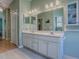 Bathroom featuring a double sink vanity with cabinets, a large mirror, and modern lighting fixtures at 910 Eagles Lndg, Leesburg, FL 34748