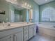 Bathroom with double vanity, shower, soaking tub, and a decorative window allowing for natural light at 910 Eagles Lndg, Leesburg, FL 34748