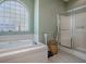This bathroom has a soaking tub, shower, and arched glass-block window for natural light and privacy at 910 Eagles Lndg, Leesburg, FL 34748