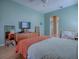 Bedroom with laminate floor, ceiling fan, TV, and view through the arch to the bathroom at 910 Eagles Lndg, Leesburg, FL 34748