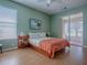 Cozy bedroom with wood-look flooring, a ceiling fan, and sliding glass doors to the screened porch at 910 Eagles Lndg, Leesburg, FL 34748