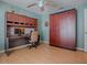 Bedroom showing a built-in desk and wardrobe, ceiling fan, and wood-look floors at 910 Eagles Lndg, Leesburg, FL 34748