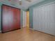 Spacious bedroom with wood-look flooring, closet, and convenient access to a hallway at 910 Eagles Lndg, Leesburg, FL 34748