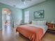 Bedroom featuring laminate flooring, a ceiling fan, and view into the en-suite bathroom with tub at 910 Eagles Lndg, Leesburg, FL 34748