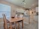 Open dining area featuring a wooden table and chairs with a clear view into the bright, modern kitchen at 910 Eagles Lndg, Leesburg, FL 34748