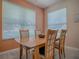 Bright dining area with a wooden table and chairs, illuminated by natural light from nearby windows at 910 Eagles Lndg, Leesburg, FL 34748