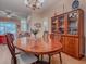Open dining area featuring a hardwood oval table and beautiful display cabinets for storing dinnerware at 910 Eagles Lndg, Leesburg, FL 34748