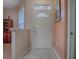 Bright entryway features a white front door, tile flooring, and natural light, creating a welcoming atmosphere at 910 Eagles Lndg, Leesburg, FL 34748